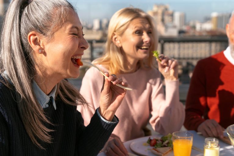 Group of friends enjoying a healthy meal together, showcasing mindful eating habits influenced by regular exercise, important for appetite control and overall well-being.
